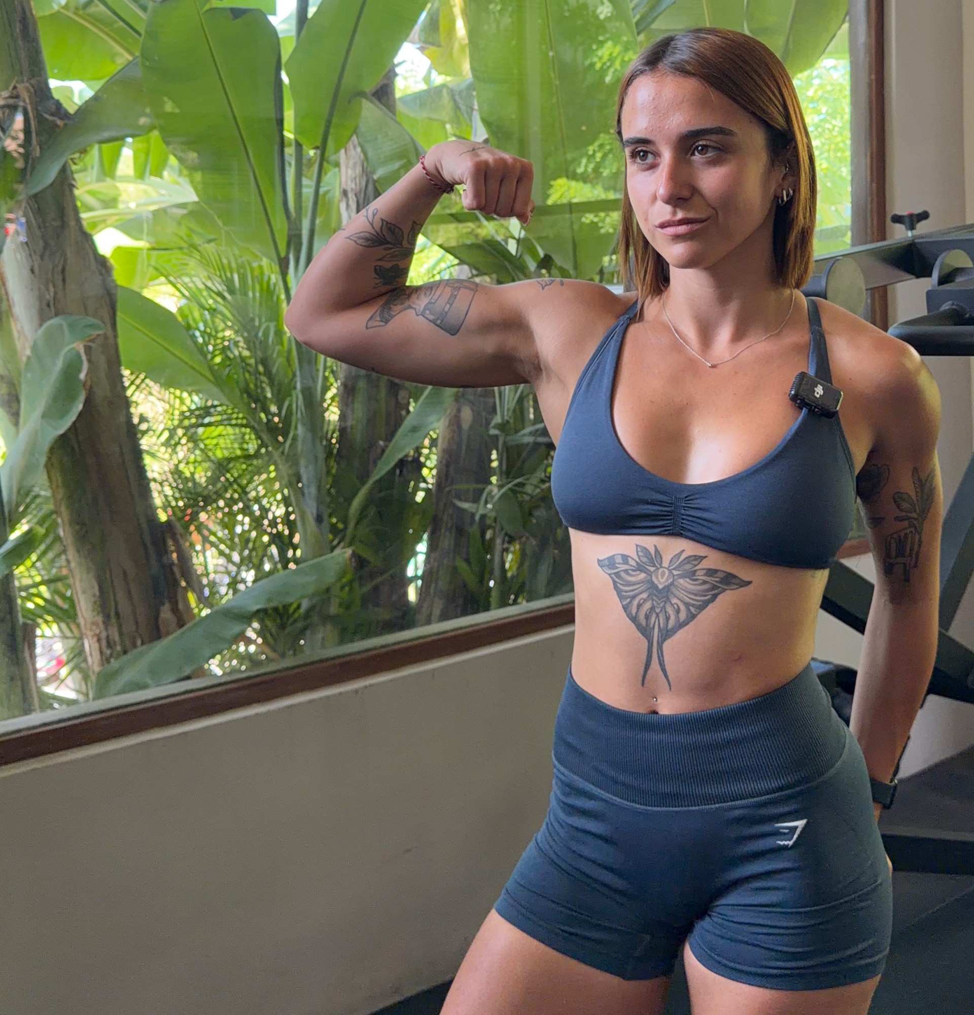 María flexionando el brazo en el gimnasio